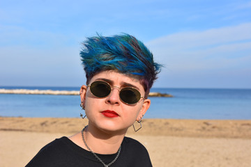 Close-up of a young dark girl posing on the sand near the sea.