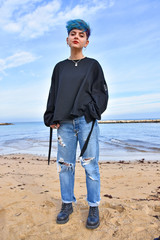 Young dark girl laying on the sand near the sea.