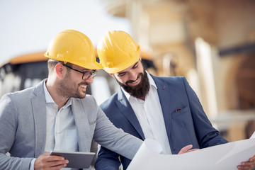 Two engineers  in hardhat using a tablet