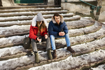 A trendy young couple walks in the city at christmastime