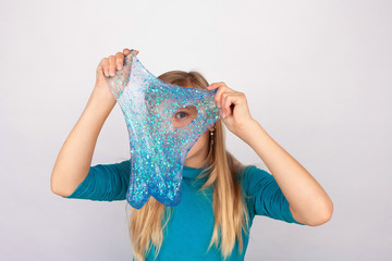 Cute girl holdin a slime in front of her face and looking through its hole