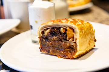 Strudel with prunes, dried apricots and nuts lying on a plate.