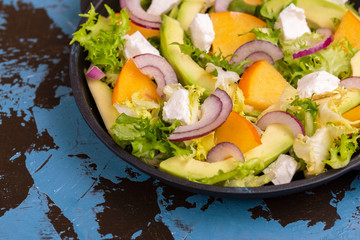 Delicious salad with frisee, persimmon, feta, chicken fillet and onion