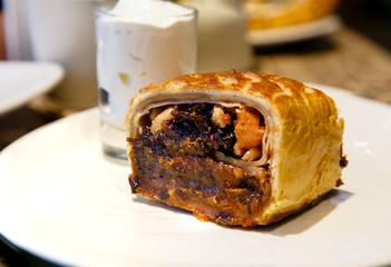 Strudel with prunes, dried apricots and nuts lying on a plate.