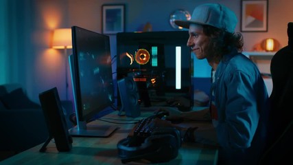 Professional Gamer Playing First-Person Shooter Online Video Game on His Powerful Personal Computer. Room and PC have Colorful Neon Led Lights. Young Man is Wearing a Cap. Cozy Evening at Home.