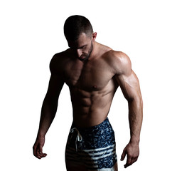 Athletic man with a muscular body poses, showing off his muscles. The concept of a healthy...