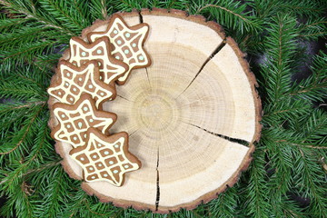 Świąteczny motyw - ręcznie malowane pierniki w kształcie gwiazdy na drewnianym pniu © Cezzar