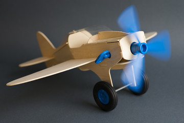 Toy wooden plane with rotating blue propeller 