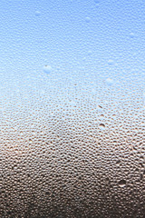 The frozen drops on the patterned frosty winter window