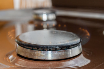 Gas stove with burning orange and blue fire on it