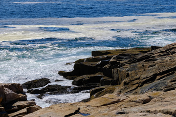 Large waves strike the pink granite rocks on the Schoodic Peninsula of Coastal Maine