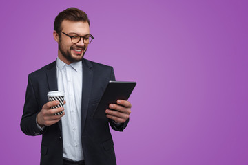 Cheerful businessman with tablet and coffee