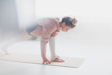 Fototapeta na wymiar Young woman training on yoga mat