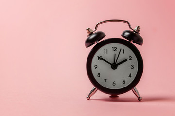 Ringing twin bell vintage classic alarm clock Isolated on pink pastel colourful background. Rest...