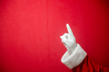 Santa Claus pointing finger on red texture background. Closeup show space. Happy New Year and Merry Christmas working design.