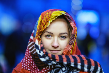 Beautiful lady looking to camera, he has colorful scarf to cover her for cold in street of Birmingham, UK 