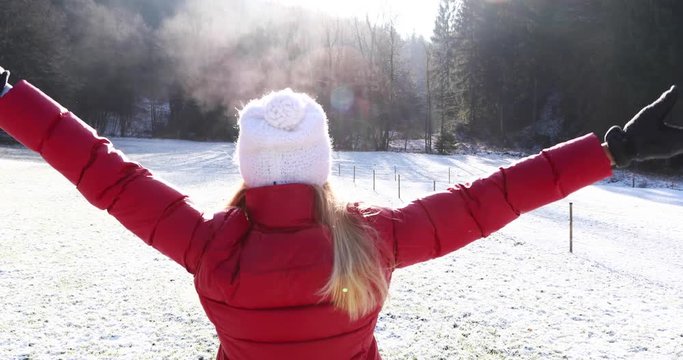  Woman walks and enjoy in sunny cold snowy winter meadow.