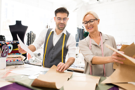 Portrait of two tailors smiling happily while working in atelier workshop, copy space