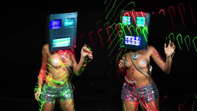 a sexy female dancer with a robot head and screens for eyes and mouthplaying distorted video footage with overlayed light effects