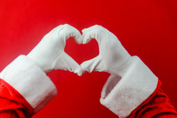 Santa claus showing love heart shape sign for Christmas and Valentines day holidays decoration background. Closeup of seasonal happiness and amazing time.
