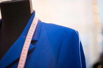 Close up of classic jacket in electric blue color shown on mannequin in atelier studio, copy space