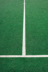 Obraz premium White lines on green soccer or football field. Perpendicular lining.
