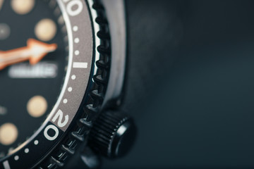 Watch close up dial, bezel and crown. Dark background. Copy space. 