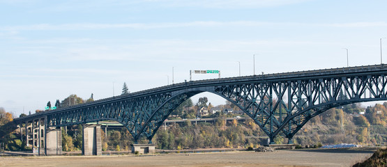 Ross island bridge in Portland, Oregon. Arc shaped cantilever truss bridge across Willamette river; connects east and west city sides.