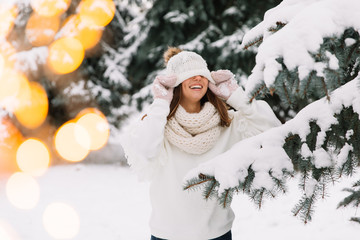 Outdoor close up portrait of young beautiful happy smiling girl wearing white knitted, scarf and...