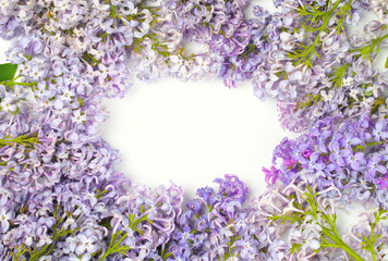 Frame of lilac flowers with space for text on white background. Flat lay, top view. Spring floral concept