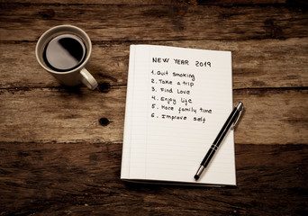 2019 New Year written on notebook with coffee on wood table on resolutions and goals for happy life