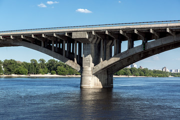 Concrete bridge pillar arch structure in river water, close-up of the support structure and columns.
