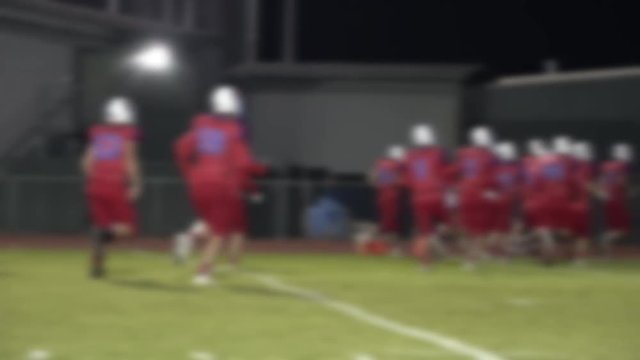 Defocused football players running into the locker room at half time