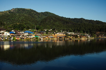 Fototapeta na wymiar The Reflection of home town in the River, Riverside view at Rak Thai Village, Mae hong son, Thailand
