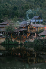 Fototapeta premium The Reflection of home town in the River, Riverside view at Rak Thai Village, Mae hong son, Thailand