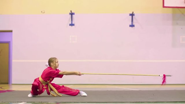 Young girl in red yifu clothes doing qiansho form exercises china kung fu tai chi. Chinese traditional wushu clothing for martial arts uniform kung fu tai chi red suit stage performance Costume