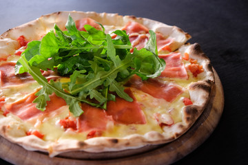  lavender flower. flowSliced pizza with prosciutto (parma ham), arugula (salad rocket) and parmesan on dark wooden background top view. Italian cuisine. Space for text.er garden. Soft focus
