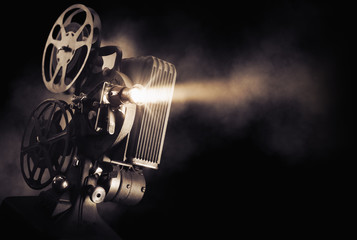 film projector on a dark background - obrazy, fototapety, plakaty