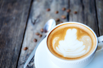Coffee cup and spoon on wooden.