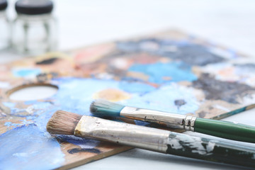 Obraz premium Artist's palette with colorful oil paint strokes and paintbrushes