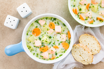 Frische cremige Suppe mit Lachs, Kartoffeln, Möhren und Petersilie, Brotscheiben an der Seite...