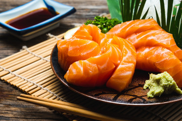 Sashimi, Salmon, Japanese food chopsticks and wasabi on the wood table
