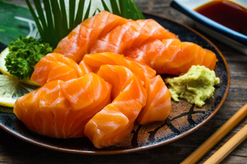 Sashimi, Salmon, Japanese food chopsticks and wasabi on the wood table