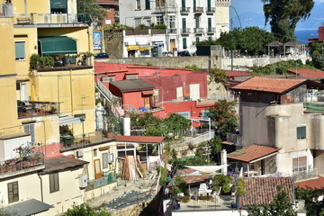 Obraz premium Typical terrace houses with mostly flat roofs on steep cliffs of Mediterranean coast of Naples in Italy.