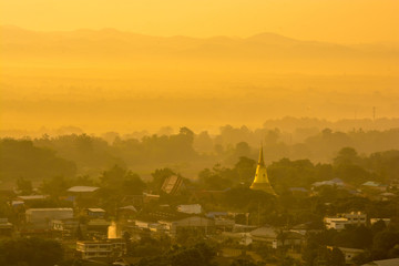 Obraz premium colorful sunrise over town with mountain range at background