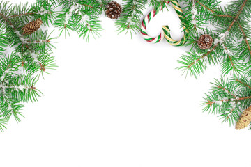 Christmas Frame of Fir tree branch with candy canes and snow isolated on white background with copy space for your text