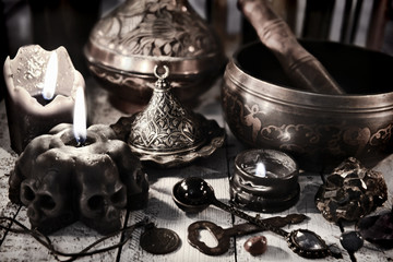 Still life with black candles, antique metal dishware, singing bowl and key. Magic ritual. Wicca, esoteric and occult background with vintage witch objects 