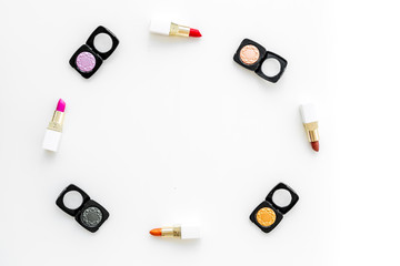 visagiste desk with decorative cosmetics: eyeshadows, lipstick white background top view space for text