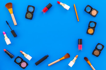female desk with decorative cosmetics for make up blue background top view mockup
