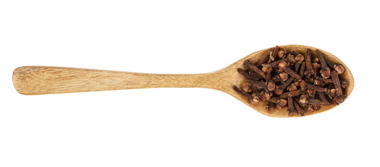 dry spice cloves in wooden spoon isolated on white background. Top view. Flat lay